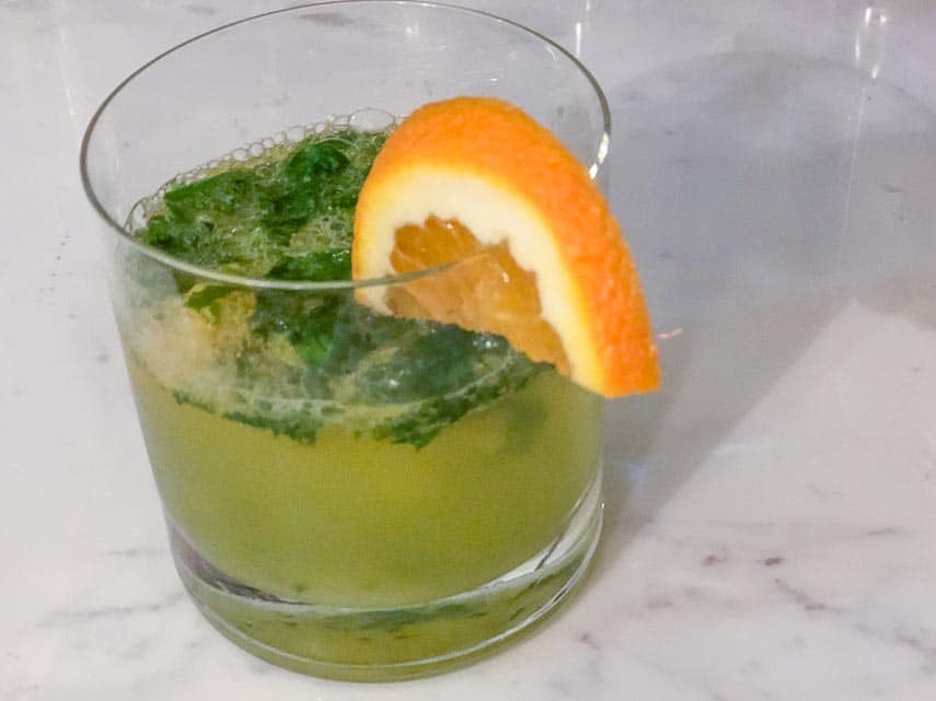 Basil orange smash in a short glass with orange wedge