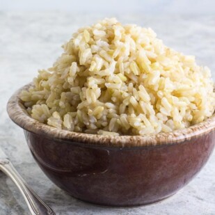 brown rice in a brown ceramic bowl with silver fork-2
