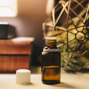 CBD oil in container, open with lid next to it on table