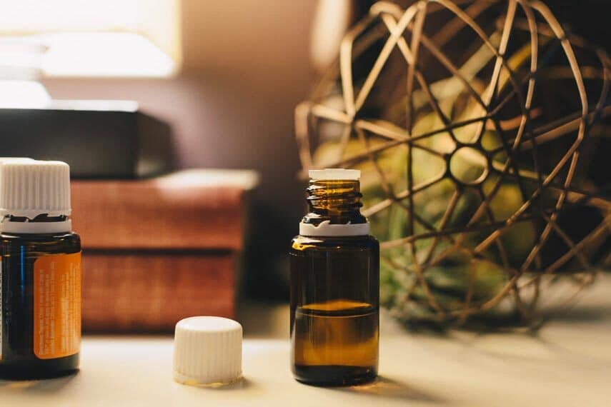 CBD oil in container, open with lid next to it on table