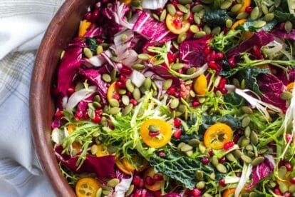 closeup horizontal of Low FODMAP Greens with Kumquats and Pomegranate
