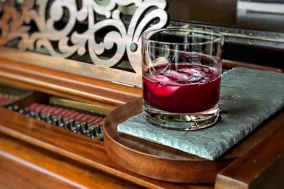 Ginger Beet Old-Fashioned in a clear glass on a piece of slate