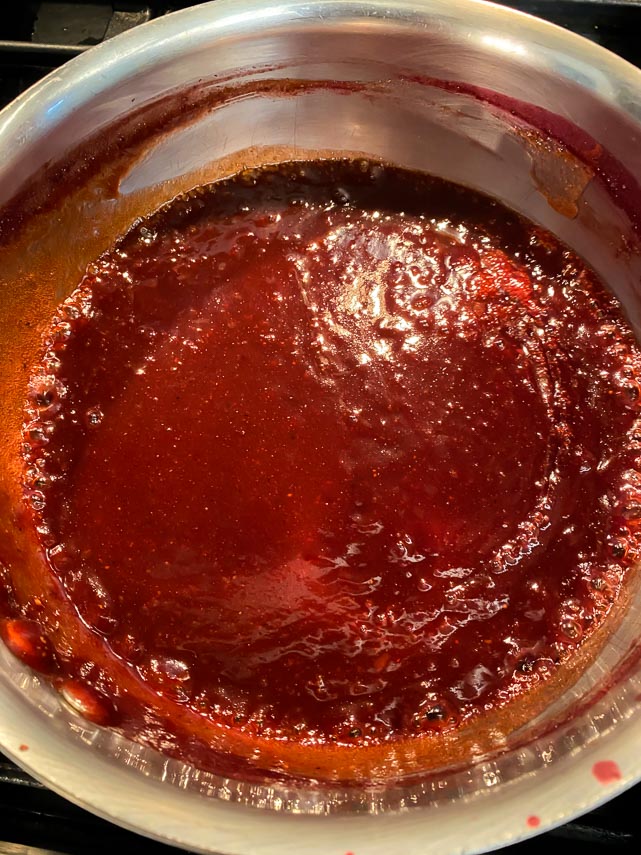 Ingredients for Blackberry BBQ sauce in saucepan, whisked together and simmering