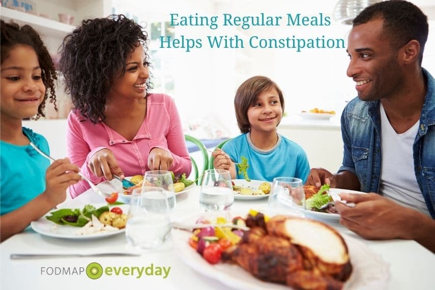 a family of 4 sitting at a table eating a meal 