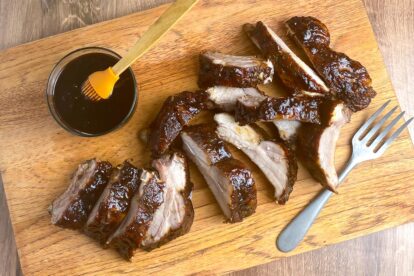 Low FODMAP 5-Spice Ribs with Plum sauce on board and with bowl of sauce.