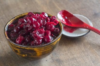 Low FODMAP Brown Sugar 5-Spice Cranberry Sauce in a dark ceramic bowl