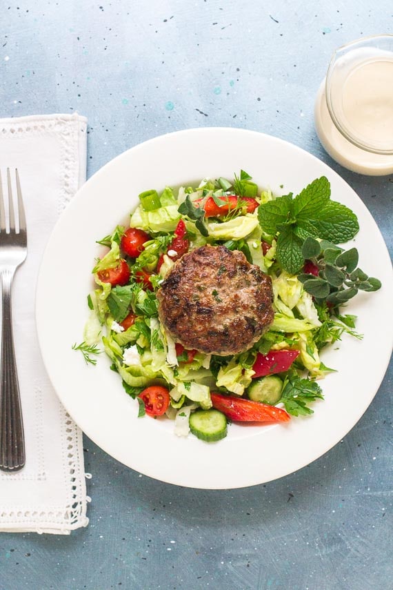 low FODMAP Burger with Tahini Sauce before it is drizzled with sauce on white plate