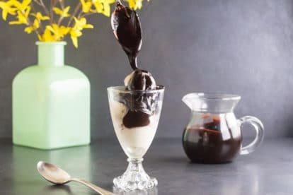 low FODMAP CBD oil Hot Fudge sauce dripping from spoon onto ice cream in glass dishCR2