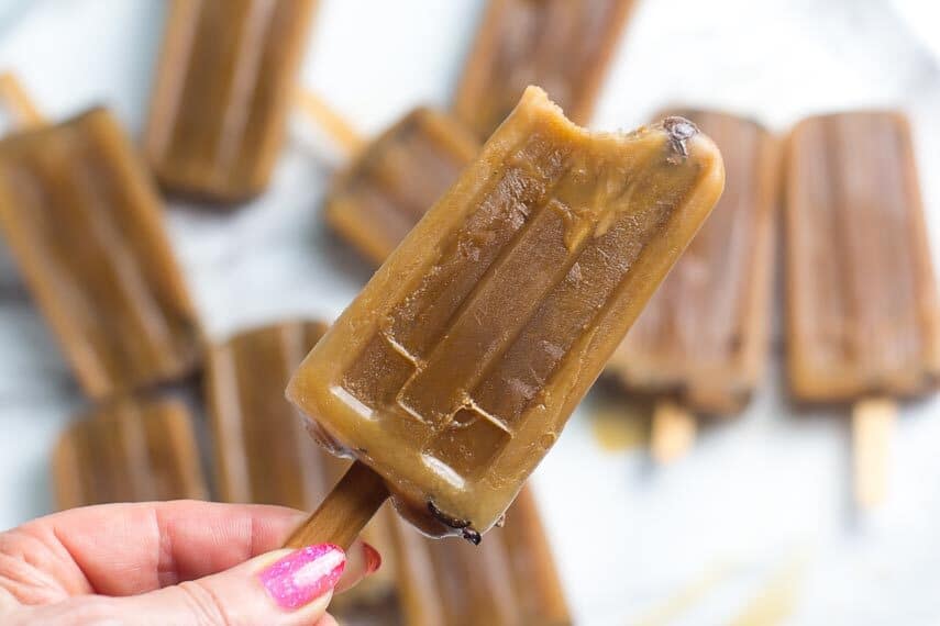 low FODMAP cold brew oat latte popsicles, bite taken out, held in hand