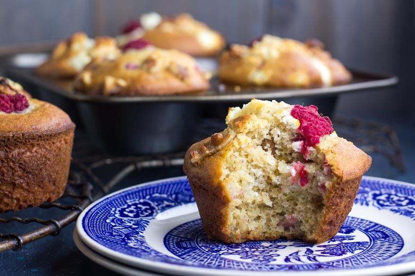 Low FODMAP Olive Oil Muffins with Goat Cheese, Walnuts and Raspberries on a blue plate; bit into