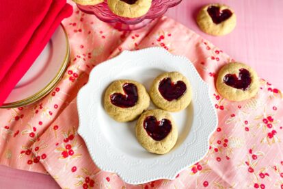 Low FODMAP Peanut Butter and Jam Hearts cookies on white plate; red napkins alongside