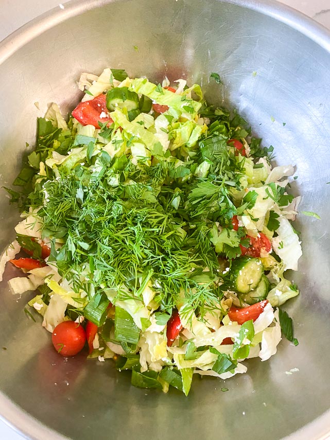 making herb salad for lamb burgers