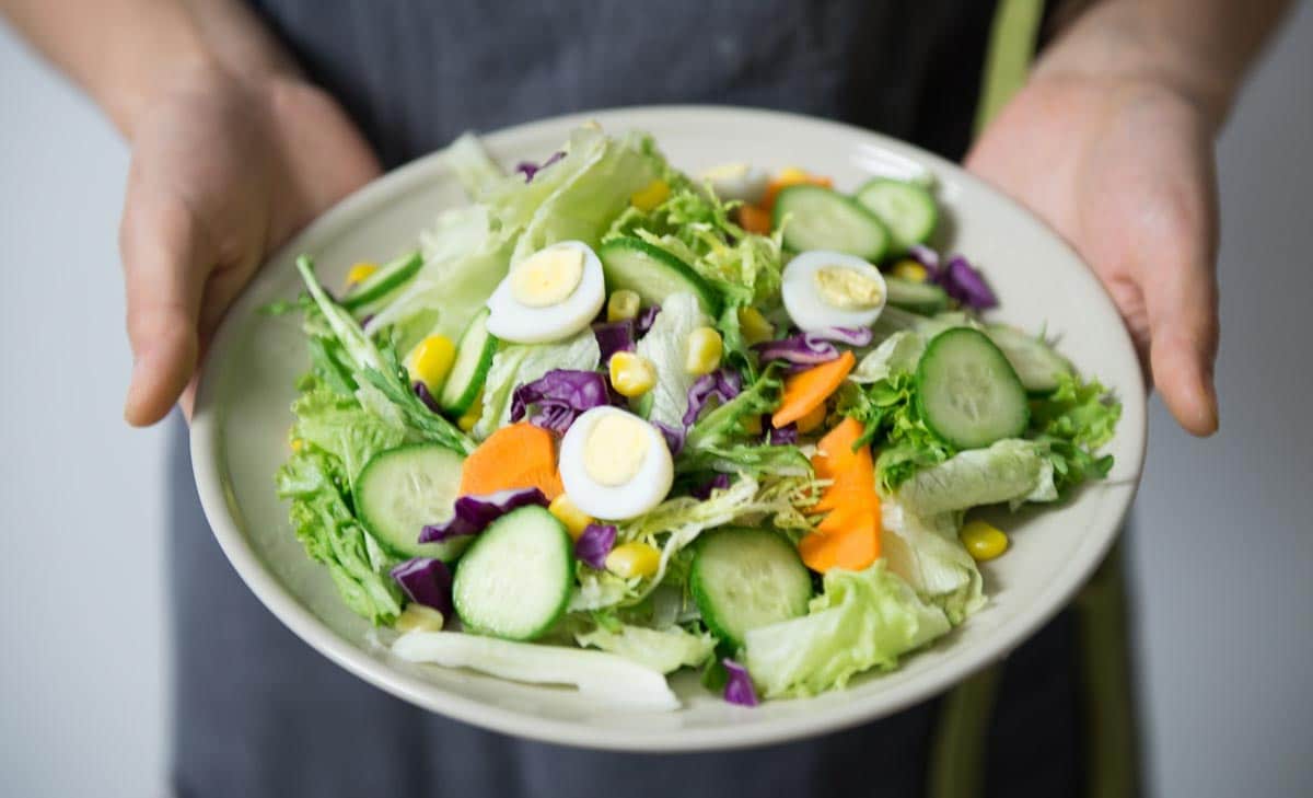 man holding bowl of salad