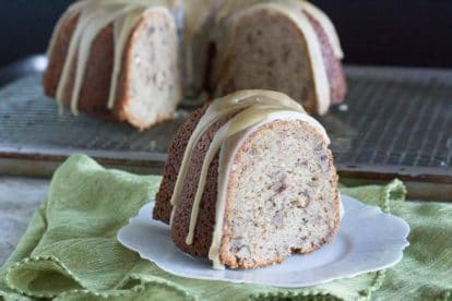 Our Low FODMAP Banana Nut Bundt Cake with Caramel Glaze on a decorative plate; whole cake in background