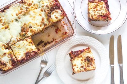 overhead view of hearty low FODMAP eggplant parmesan in pan and on white plate