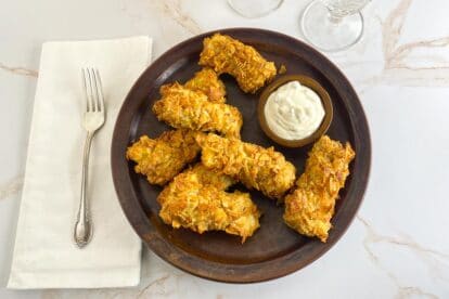 overhead air fryer low FODMAP fish sticks on marbled background and brown plate