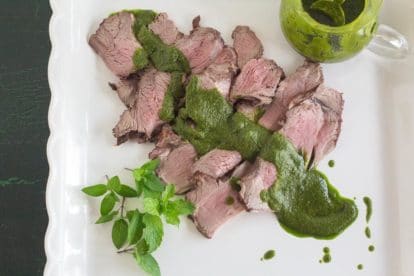 overhead image of Grilled Butterflied Leg of Lamb with Mint Salsa Verde on square white platter