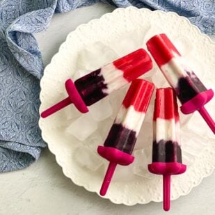 overhead image of vegan red, white and blue popsicles on white plate