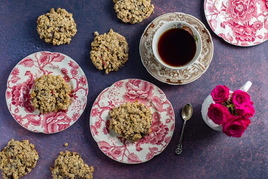 Low FODMAP Apple Oat Breakfast cookies on pink and white decorative plates; coffee and roses alongside