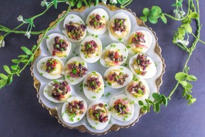 overhead of Low FODMAP Muffuletta Deviled Eggs on gold edged egg plate