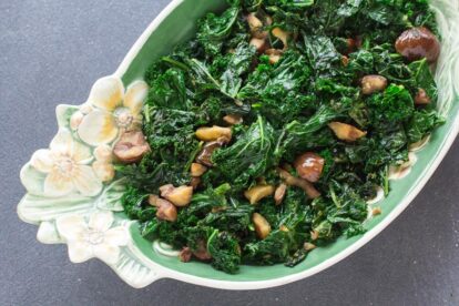 overhead view of Garlicky Low FODMAP Sautéed Kale with Chestnuts in oval decorative bowl