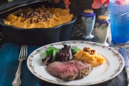plated low FODMAP horseradish crusted roast beef with casserole of mashed sweet potatoes in backrgound