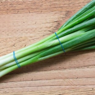 scallion bunch on wooden board