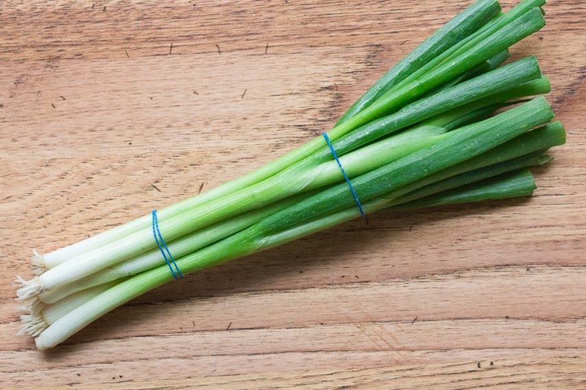 scallion bunch on wooden board