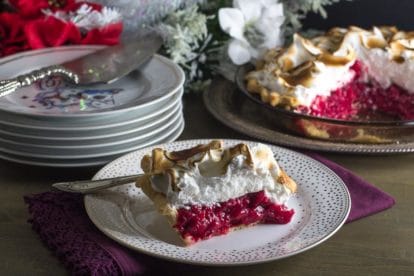 slice of cranberry snowdrift pie on a decorative plate; whole pie in background