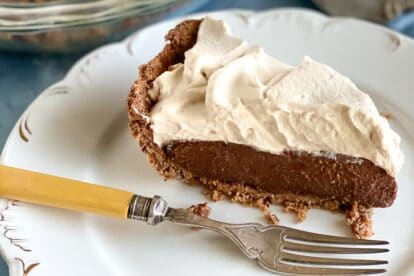 slice of Low FODMAP Black Bottom Pie wedge on white plate on blue background
