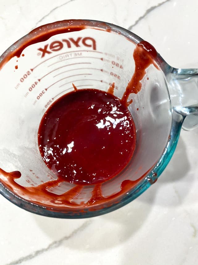 strained blackberry purée in measuring cup