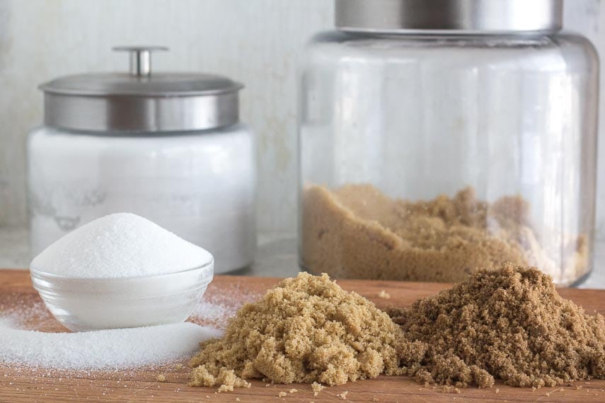 All About Sugar. Sugar and brown sugars on a wooden board