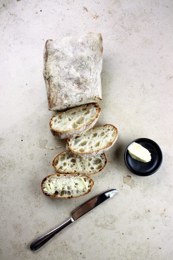 loaf of artisan bread on light background, sliced loaf of artisan bread on light background, sliced