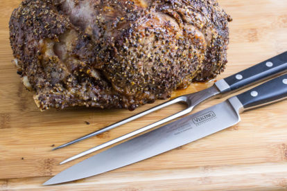 viking carving set on cutting board next to cooked rib roast