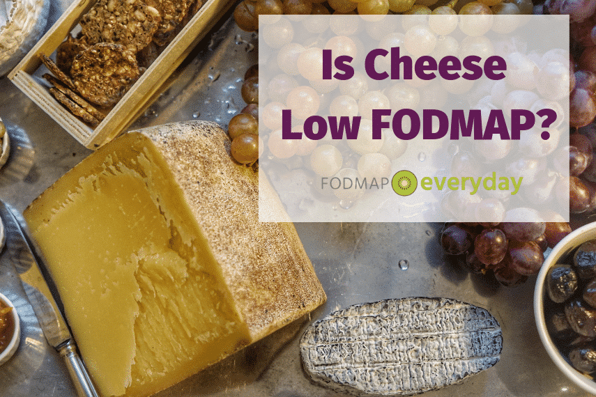 A huge chunk of farmstead cheese on a platter with grapes and appetizers
